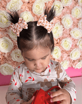 Little girl is wearing a set of bow clips for toddler girls from By Bella Boutique.